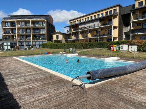 a swimming pool in a building with two people in it at Les pieds dans l eau in Erpion