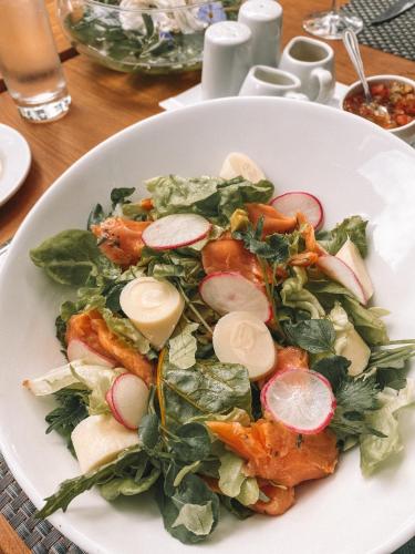 a white plate with a salad on a table at Leonera Hotel in La Leonera