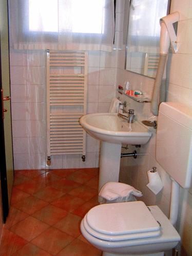 a bathroom with a white sink and a toilet at Albergo Ristorante Da Giuseppe in Copparo