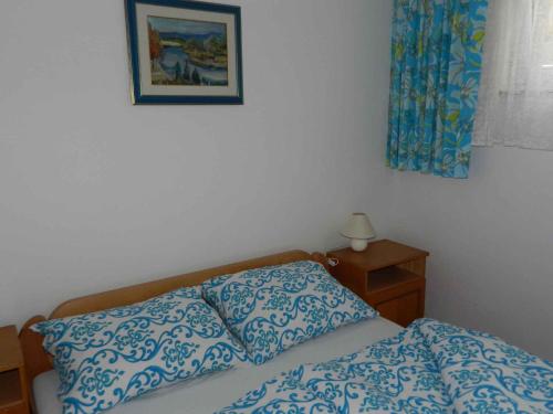 a bedroom with a bed and a picture on the wall at Two-Bedroom Apartment in Malinska I in Sveti Vid-Miholjice