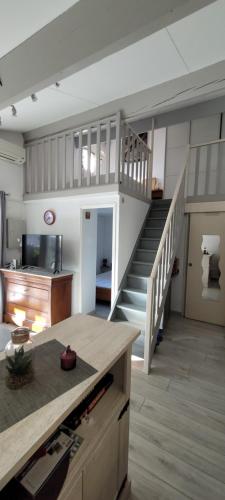 een woonkamer met een trap en een trap bij LE MIRABILIS in La Motte