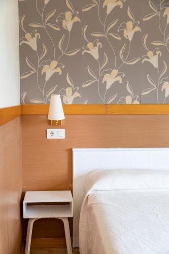 a bedroom with a bed and a table with a lamp at Hotel Ría de Suances in Suances