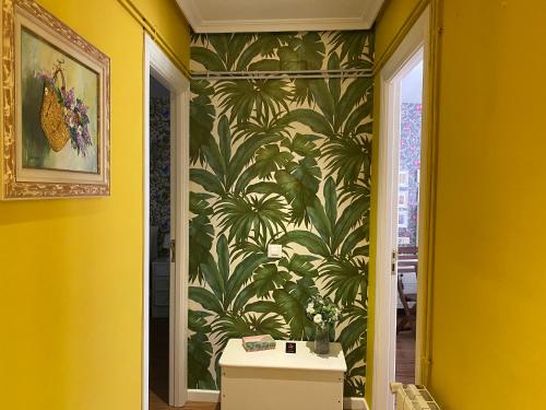 a hallway with a wall mural of palm trees at Apartamento La Biblioteca en Cuenca in Cuenca