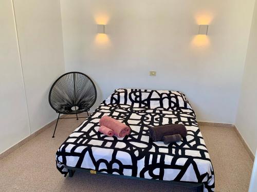1 dormitorio con 1 cama en blanco y negro y 1 silla en Fuerteventura apartament Monny Moulin View Antigua Wi-Fi, en Valles de Ortega