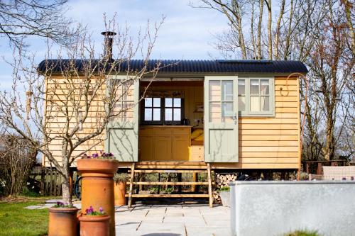 a tiny house on a patio in a yard at Little Plovers Shepherd Hut in Chichester