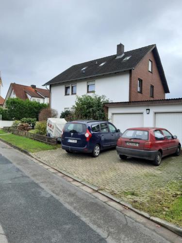 deux voitures garées dans une allée devant une maison dans l'établissement Haus Andreasse am Wiehengebirge, à Minden