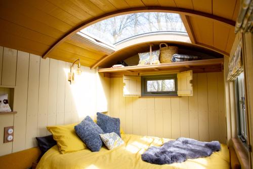 a bedroom with a bed in a room with a window at Little Plovers Shepherd Hut in Chichester