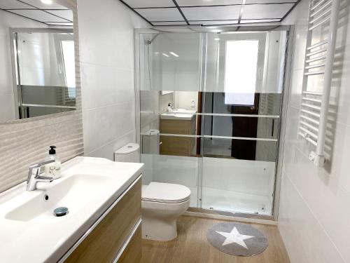 a bathroom with a toilet and a glass shower at Comfortable seaside apartment in Salou - 85 m² - Sea view in Salou