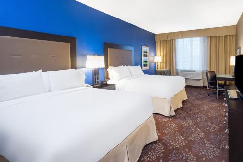 a hotel room with two beds and a desk at Holiday Inn - Terre Haute by IHG in Terre Haute