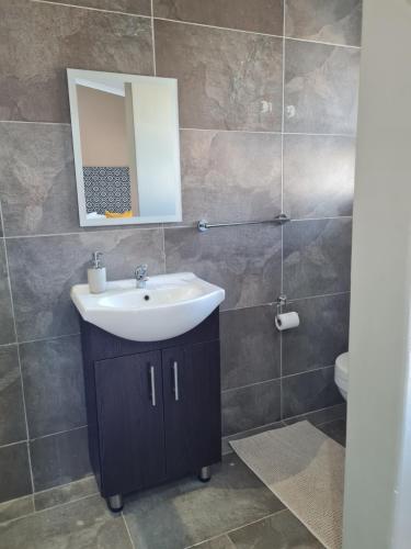 a bathroom with a sink and a mirror at Village Kulture - Guest House in Rustenburg