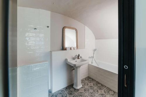 a white bathroom with a sink and a bath tub at Hotel la Robeyere; BW Signature Collection in Embrun