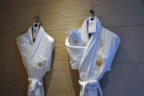 two white towels are hanging on a wall at Cottage de la Tour - Duplex troglodyte of 100 m in Azay-le-Rideau