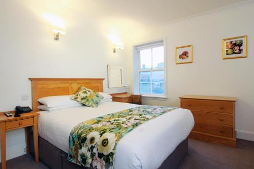 a bedroom with a large bed and a window at Harry Clarke Mews at the Castle Hotel in Dublin