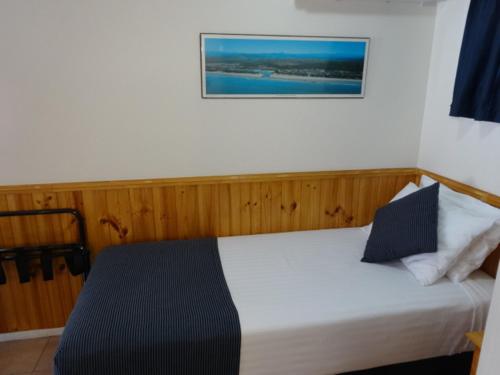 a bedroom with a bed with a picture on the wall at Twin Towns Motel in Tweed Heads