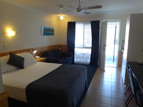 a hotel room with a bed and a living room at Twin Towns Motel in Tweed Heads