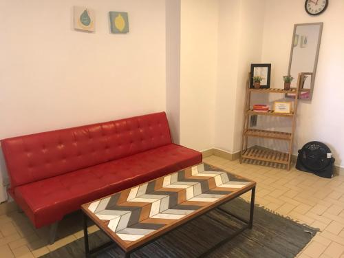 un sofá rojo sentado en una sala de estar en Departamento Belgrano 4 en Salta