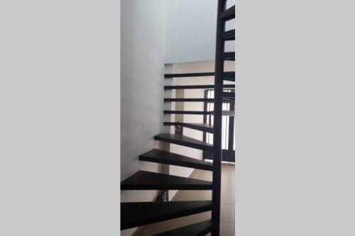 a black spiral staircase in a white room at Apartamento La Floresta con todas las comodidades in Bogotá