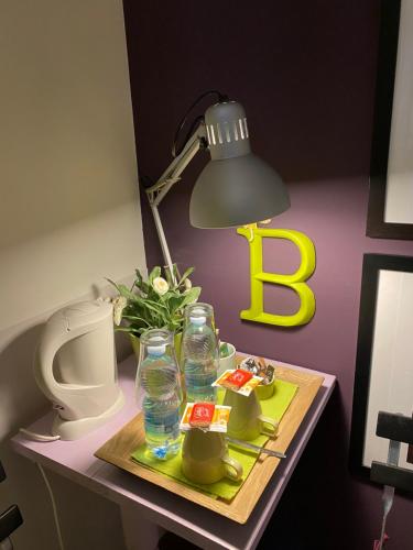 a table with a lamp and a tray with water bottles at B&B Binot in Carmagnola