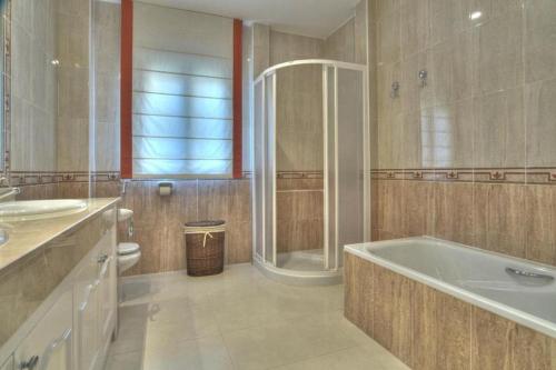 uma casa de banho com uma banheira, um chuveiro e um WC. em La Manga Club Resort - Monte Verde 352 em Atamaría