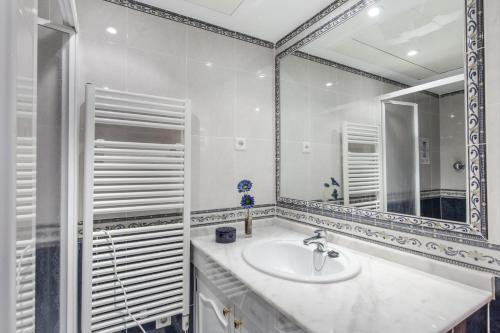 ein weißes Badezimmer mit einem Waschbecken und einem Spiegel in der Unterkunft La Manga Club Resort - Los Olivos 32 in Atamaría