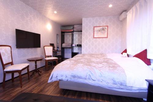 a bedroom with a bed and a desk and a tv at Yatsugatake Guest House Matsuda House - Vacation STAY 11086 in Hokuto