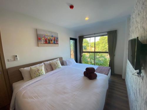 a teddy bear sitting on a bed in a bedroom at La HABANA Condo 135/500 in Hua Hin