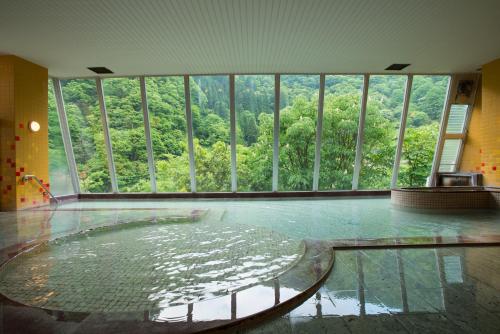 a room with a large window and a glass floor at Hotel Kurobe in Kurobe