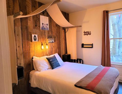 1 dormitorio con 1 cama con pared de madera en Mrs. Anderson's Lodging, en Leavenworth