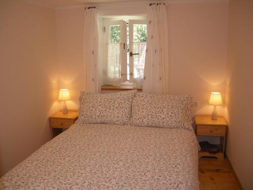 a bedroom with a bed with two lamps on two tables at Welcome to Casa Terracotta a cosy self-catering holiday home. in Masanti