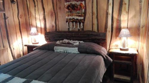 سرير أو أسرّة في غرفة في Wonderful rustic cottage with native logs, with river Trancura