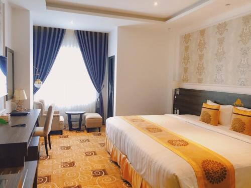 a hotel room with a bed and a desk and a window at ELIZABETH HOTEL in Thu Dau Mot