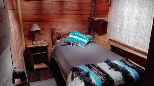 a bedroom with a bed in a log cabin at Cabaa rstica 2 maravillosa,con troncos nativos, con orilla de Ro Trancura in Pucón