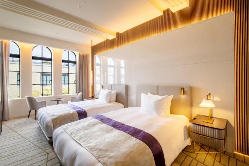 two beds in a hotel room with windows at The Hotel Seiryu Kyoto Kiyomizu - a member of the Leading Hotels of the World- in Kyoto