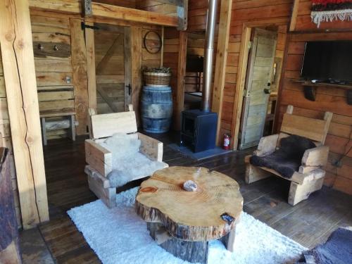 a living room with a coffee table and a barrel at Cabaa rstica 2 maravillosa,con troncos nativos, con orilla de Ro Trancura in Pucón