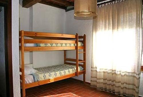 two bunk beds in a room with a window at Apartment immersed in the green of the Maremma in Massa Marittima