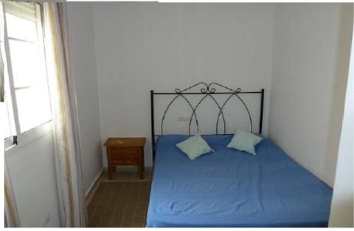 ガルチャにあるGARRUCHA 1, 2 rooms 200 meters from the sea, garageのベッド(青いシーツ、青い枕付)