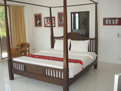 a bedroom with a wooden canopy bed with white sheets at Sunrise Villas Koh Samui- enjoy your Holiday in Thong Son Beach