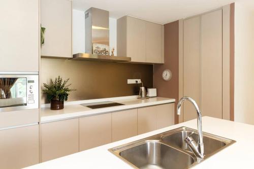 a kitchen with white cabinets and a sink at Cozy Spacious 2BR Bukit Bintang With Lush Greenery in Kuala Lumpur