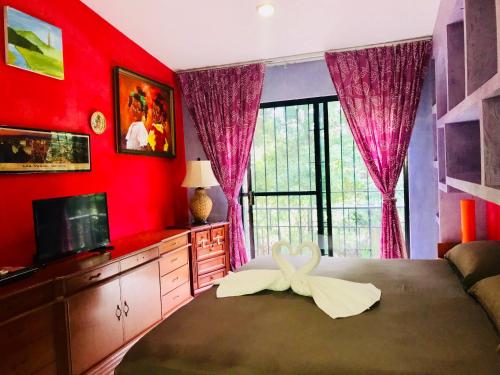 a bedroom with red walls and a large window at Sunrise Double Room in Stunning Villa Playacar Ii in Playa del Carmen