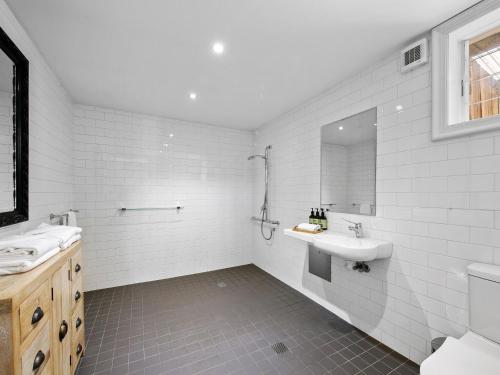 een witte badkamer met een wastafel en een spiegel bij Block Eight Estate Vineyard View Villa in Belford