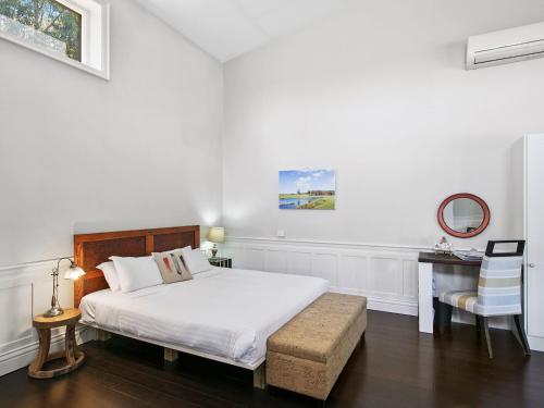 een slaapkamer met een bed, een tafel en een stoel bij Block Eight Estate Vineyard View Villa in Belford