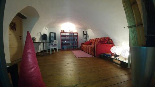 een woonkamer met een rode bank en een tafel bij Dimora Aganoor: the guesthouse - relais & gourmet - a few steps from the divine in Cava deʼ Tirreni
