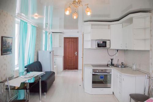 a kitchen and living room with a couch and a table at Hotel Mir in Izhevsk