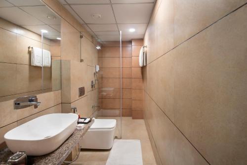 a bathroom with a white toilet and a sink at SK Lords Inn Ahmedabad in Ahmedabad