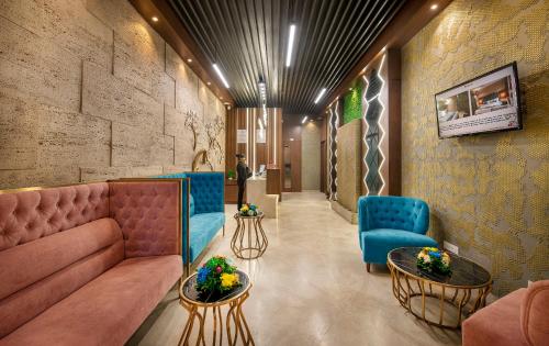 a lobby with a couch and two blue chairs at SK Lords Inn Ahmedabad in Ahmedabad