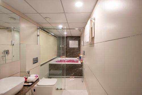 a bathroom with a shower and a toilet and a sink at SK Lords Inn Ahmedabad in Ahmedabad