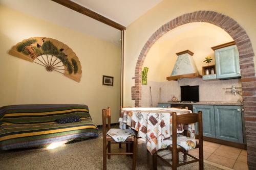 マッサ・マリッティマにあるTuscan Rustic Apartmentのアーチ道、テーブル、椅子付きのキッチン