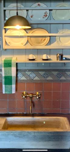 a sink in a kitchen with plates on the wall at Montanema Handmade Village in Platanákos