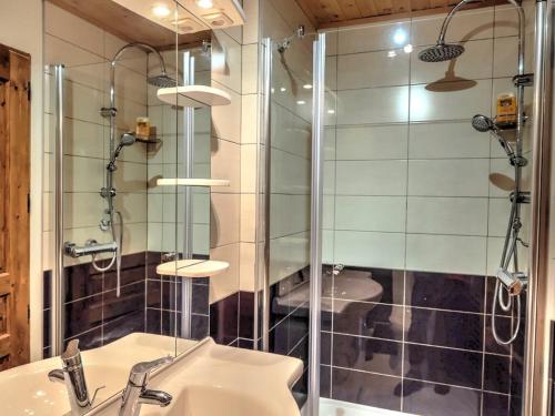 a bathroom with a glass shower and a sink at Chalet Soleil in Landry