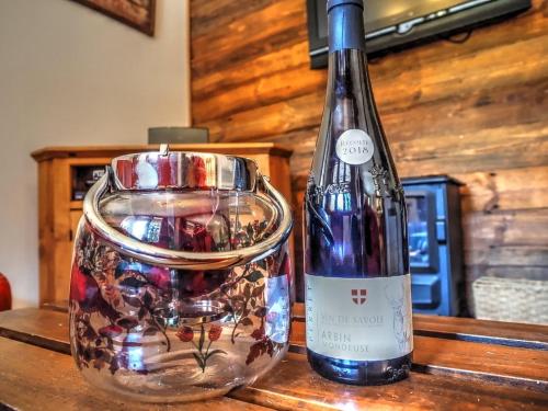 - une bouteille de vin et un pot de verre sur une table dans l'établissement Chalet Soleil, à Landry